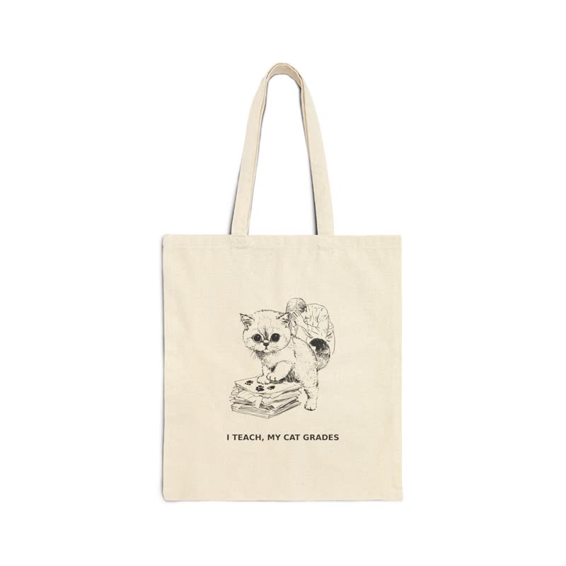 Natural canvas tote bag printed with a kitten on a stack of papers and the line “I teach, my cat grades”